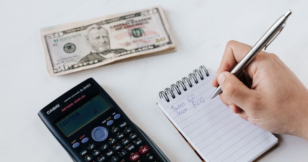 Persona anotando cifras en una libreta junto a billetes, ilustrando el cálculo de los dividendos que pagan las empresas de la Bolsa Mexicana de Valores