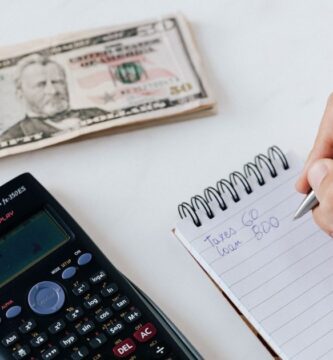 Persona anotando cifras en una libreta junto a billetes, ilustrando el cálculo de los dividendos que pagan las empresas de la Bolsa Mexicana de Valores