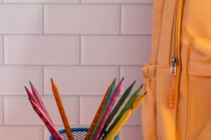 Mochila y útiles escolares de colores listos sobre una mesa para planear el presupuesto de regreso a clases 2026