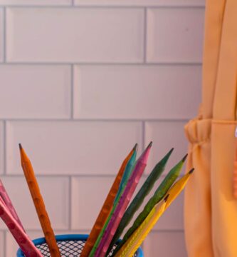 Mochila y útiles escolares de colores listos sobre una mesa para planear el presupuesto de regreso a clases 2026