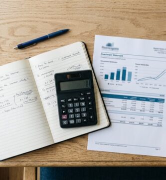 Persona revisando documentos fiscales y estados de cuenta de inversión con una calculadora sobre un escritorio